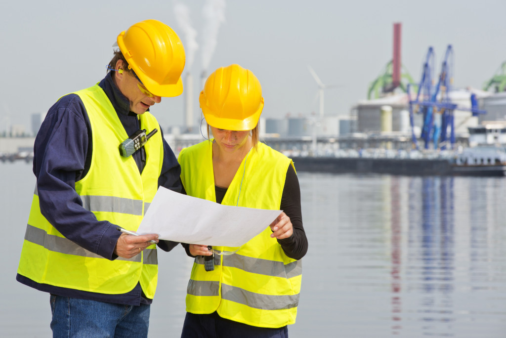 Two,engineers,,wearing,safety,gear,,including,goggles,,hard,hat,,ear